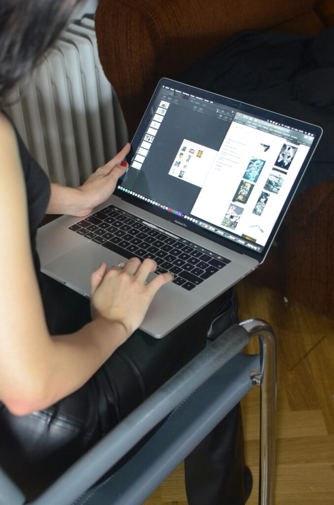 Side view of unrecognizable female freelancer browsing modern netbook while sitting in chair in room during remote work at home